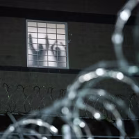 Detainees stand by a window at Delaney Hall, an ICE facility in Newark, N.J., on May 26, 2026.