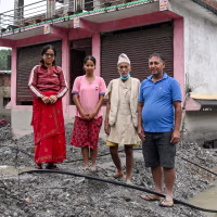 Residents of Nepal's Nuwakot district in front of their damaged shop.