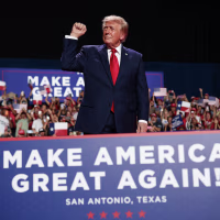 President Trump on stage during an indoor rally.