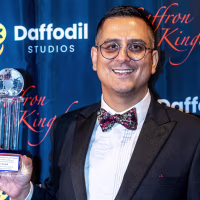 Arfat Sheikh holding an award.
