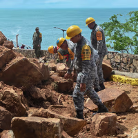 Members of the military and National Guard clear rubble outside