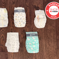 Nine disposable diapers in two rows on a dark wood floor, including Coterie, Pampers, Millie Moon, Huggies, bumbum and Rascals, with a red Shop TODAY Ranked 2026 badge.