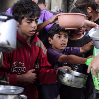 Image: Hot meals distributed to Palestinians in central Gaza's Nuseirat camp