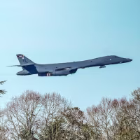 A USAF Rockwell B-1 Lancer bomber flies over the village church of St. Mary the Virgin