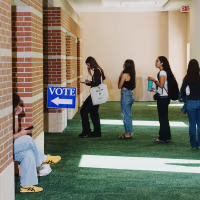 Voters wait in line to cast their ballots at a polling location on the first day of early voting for the midterm election in Texas