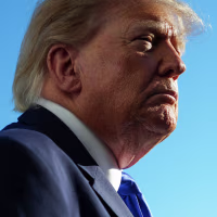 Donald Trump seen in profile view against a clear blue sky.