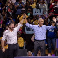 Barack Obama, Abdul El-Sayed and Jocelyn Benson join hands on stage during a rally.