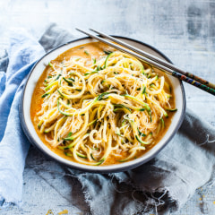 Asian style noodle soup with glas noodles and zoodles in red curry broth