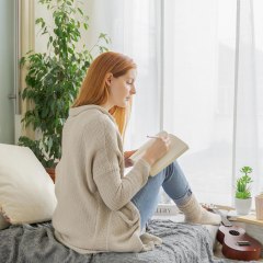Woman bullet journaling in her bedroom