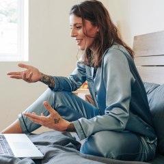 Woman in silk pajamas sitting on bed and having video conference. See the best silk pajamas for women to try in 2021. Shop silk pajamas that are affordable and washable from Lunya, Nordstrom and more.