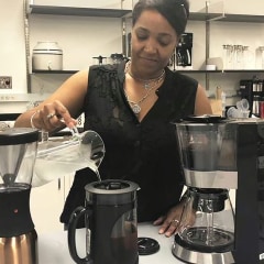 A CR test engineer pours water into a cold brew coffee maker.