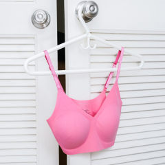 Split image of a bra hanging on a hanger and Smiling girl looking at female friend in sports court
