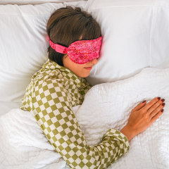 Woman sleeping in bed with a sleep mask