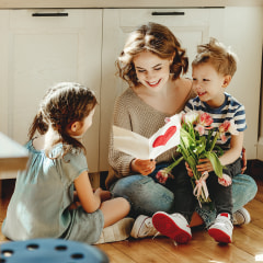 Happy mother getting gifts from kids at home