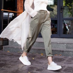 street fashion style. Beautiful Sexy Woman Wearing Fashionable Spring Or Fall Clothes (beige trench coat, cargo pants, accessorie) Outdoors. Female stylish Model walking Street. Autumn trend