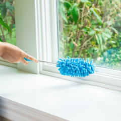 Hand dusting a window sill