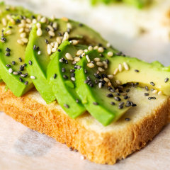 Avocado cut into slices on a piece of toast, topped with sesame and chia seeds.