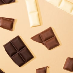 top view of delicious dark, milk and white chocolate pieces on beige background