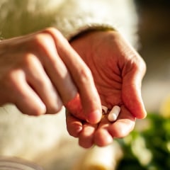 Young woman taking a health supplement in the kitchen.