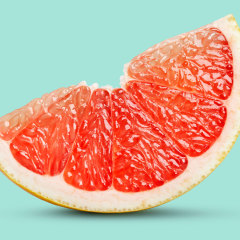 Perfect red grapefruit slice on pastel green