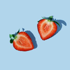 Two slices of strawberry on the blue background