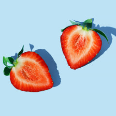 Two slices of strawberry on the blue background.