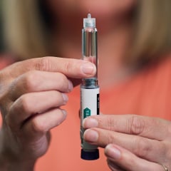 A woman prepares her dose of a weight loss injection using a Semaglutide pen.