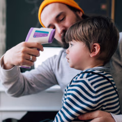 Man using a thermometer on his son and a Woman taking her temperature