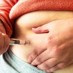 Woman using injection pen to administer weight loss drug