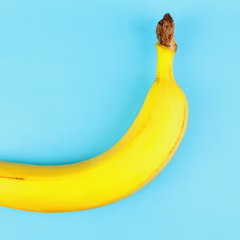 Single yellow banana on sky blue background