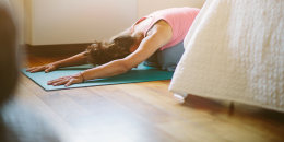 image: Mid adult woman in yoga position on bedroom floor
