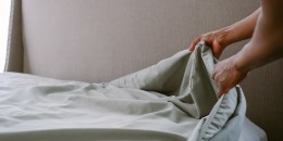 Woman Puts Sheet on Bed