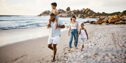 Shot of a young couple and their two kids spending the day at the beach