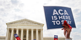 A person holds at sign that reads "ACA Is Here To Stay" at the Supreme Court