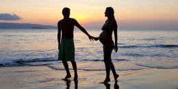 Romantic pregnant couple on beach