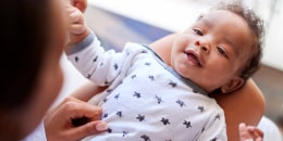 Happy three month old baby boy lying on his back on his back.