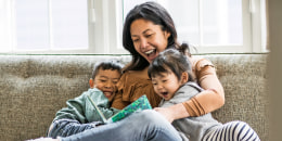 Mother reading to kids on couch
