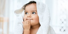 Shot of an adorable baby covered in a towel after bath time