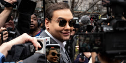 Rep. George Santos, R-N.Y., smiles while surrounded by members of the media.