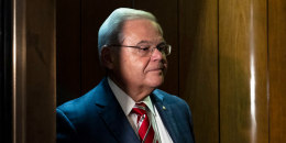 Doors begin to close in a wood paneled elevator with Bob Menendez inside
