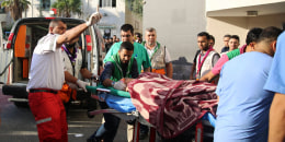 Medics push a wounded Palestinian into a hospital on a stretcher