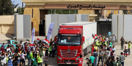 Egyptian aid workers celebrate as a truck crosses back into Egypt through  of the Rafah Border crossing on Oct. 21, 2023. 