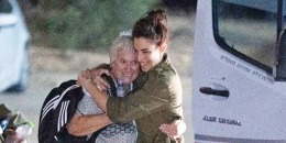 An Israeli soldier embraces former Hamas hostage as she exists a van