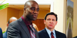 Gov. Ron DeSantis looks at Joseph Ladapo speak at a news conference in West Palm Beach, Fla.,