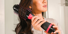 woman using a brush to curl her hair