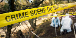 Police crime scene investigators look for evidence at burial site.