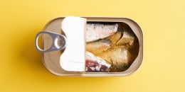 Canned sardines on a yellow background