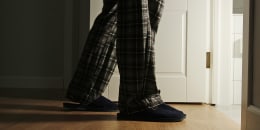 Man in a pajamas and slippers walks to a toilet at home in the night.