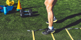 Man legs training with agility ladder and cones on the side