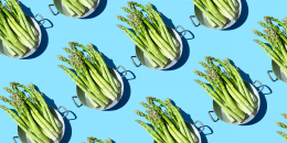 Repeated asparagus in a pan on the blue background
